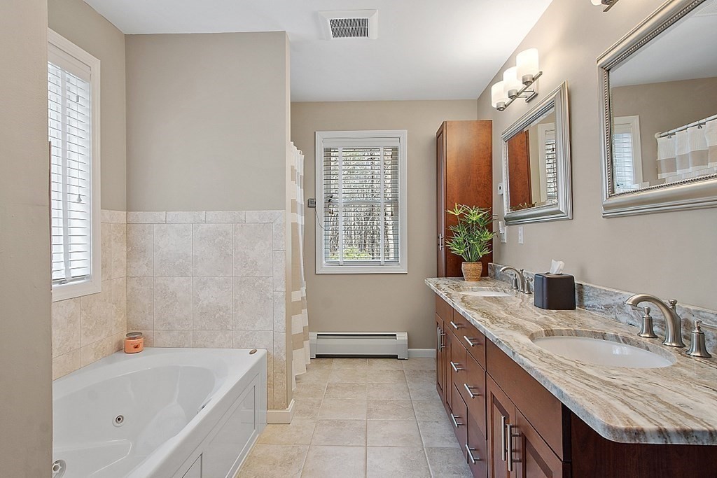 9 Joco Drive Tyngsborough, MA 01879 - Photo 22 of 38 a bathroom with a granite countertop tub a sink and a large mirror