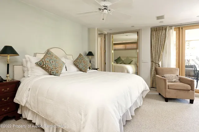 a large bed sitting in a bedroom next to a window