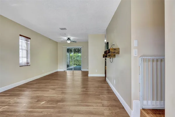 a view of a hallway with a window and wooden floor