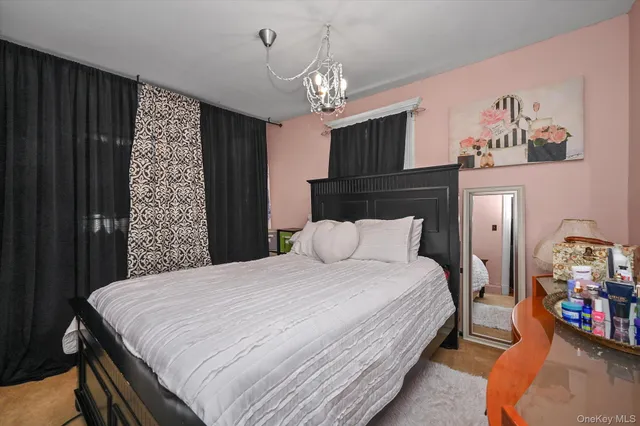 a bedroom with bed and a chandelier