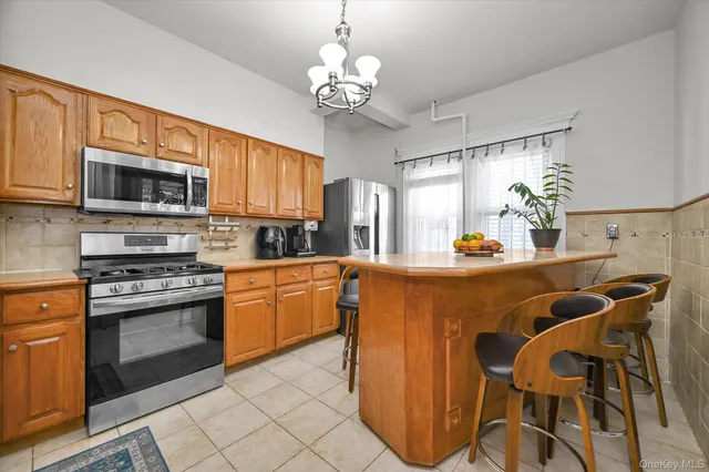 a kitchen with stainless steel appliances granite countertop a stove top oven a sink dishwasher a dining table and chairs with wooden floor