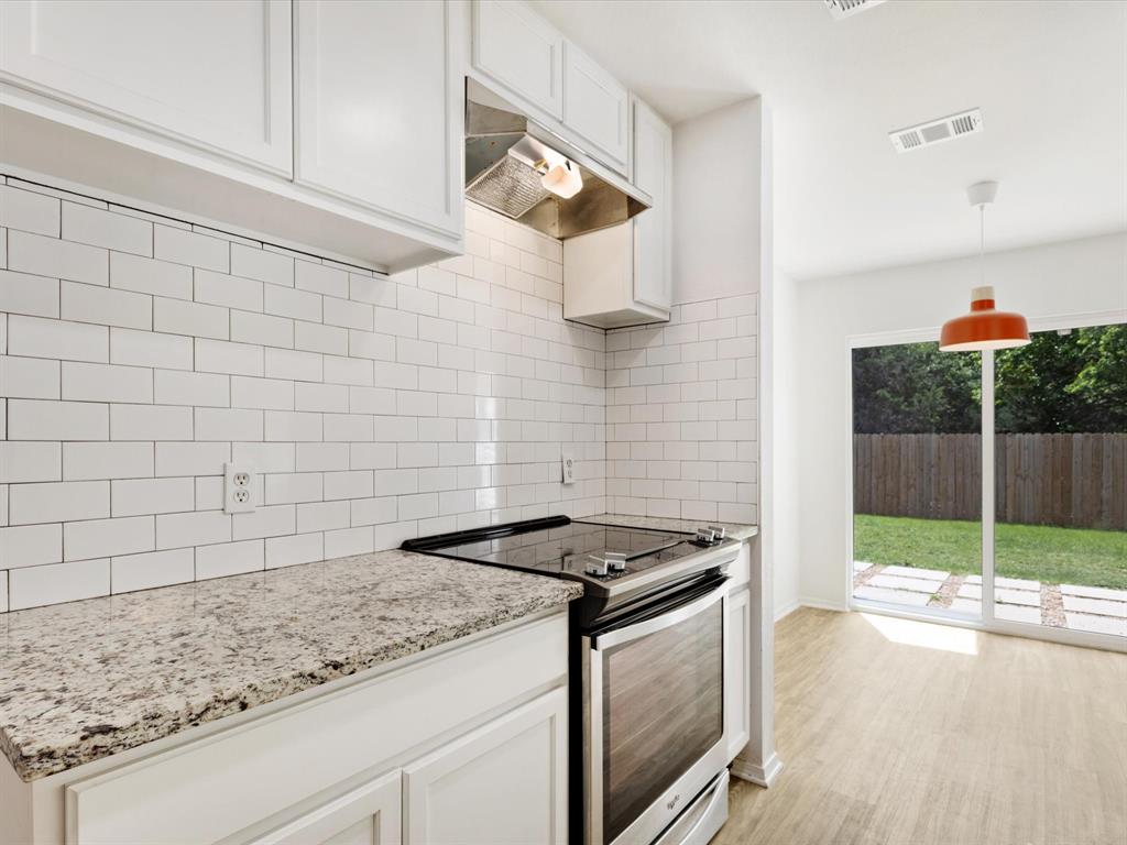 6702 Umphress Road Dallas, TX 75217 - Photo 13 of 22 a kitchen with granite countertop a stove a sink and a microwave