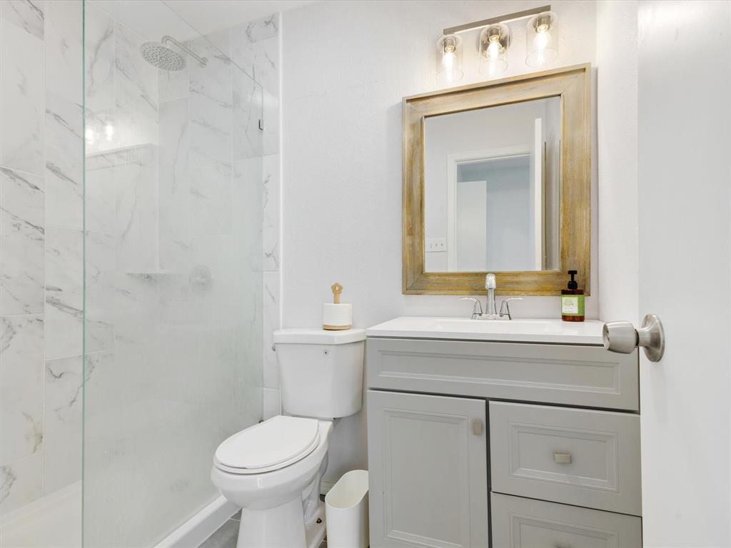 6702 Umphress Road Dallas, TX 75217 - Photo 6 of 22 a bathroom with a toilet sink vanity and mirror