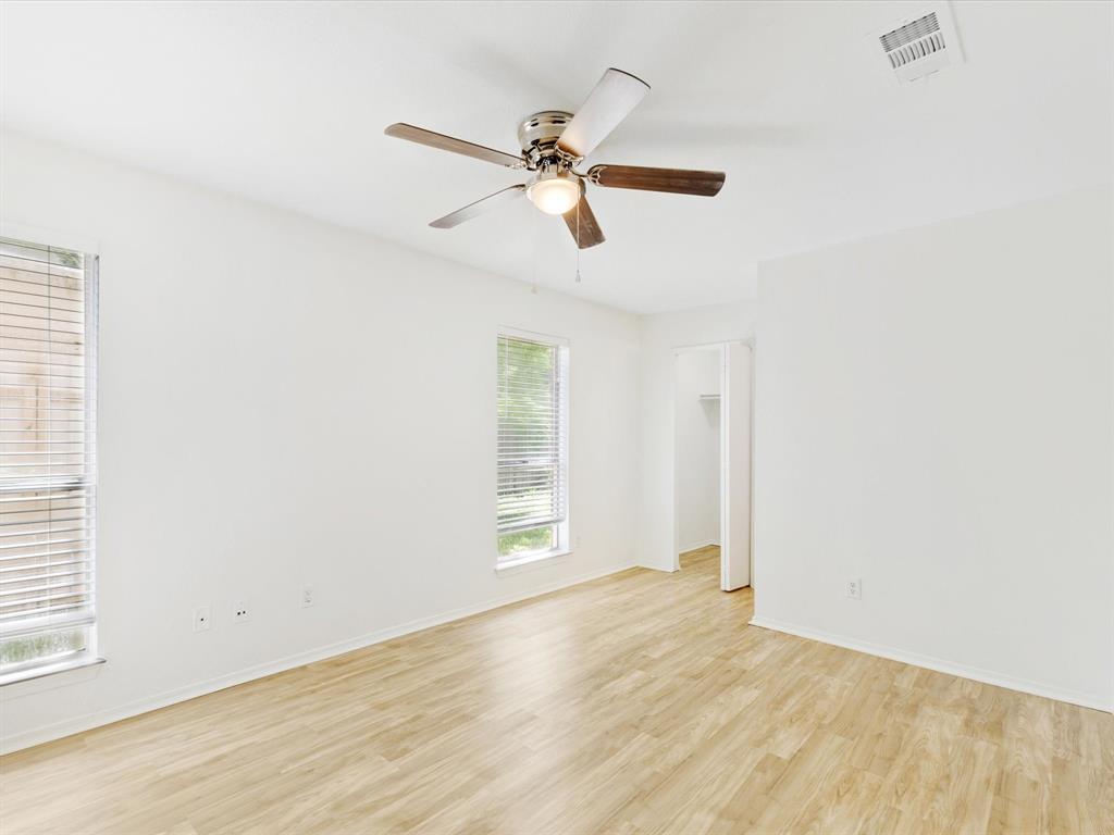 6702 Umphress Road Dallas, TX 75217 - Photo 9 of 22 an empty room with wooden floor ceiling fan and windows