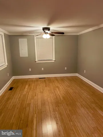a view of a room with wooden floor and white walls