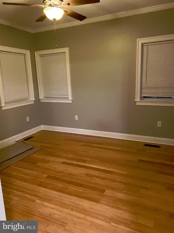 a view of a room with wooden floor and fan