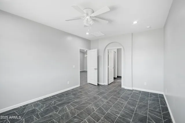 an empty room with a ceiling fan and shower