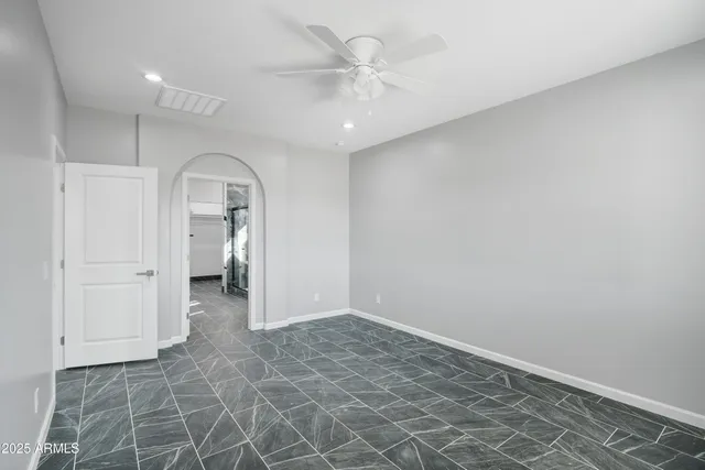 an empty room with a space and a ceiling fan