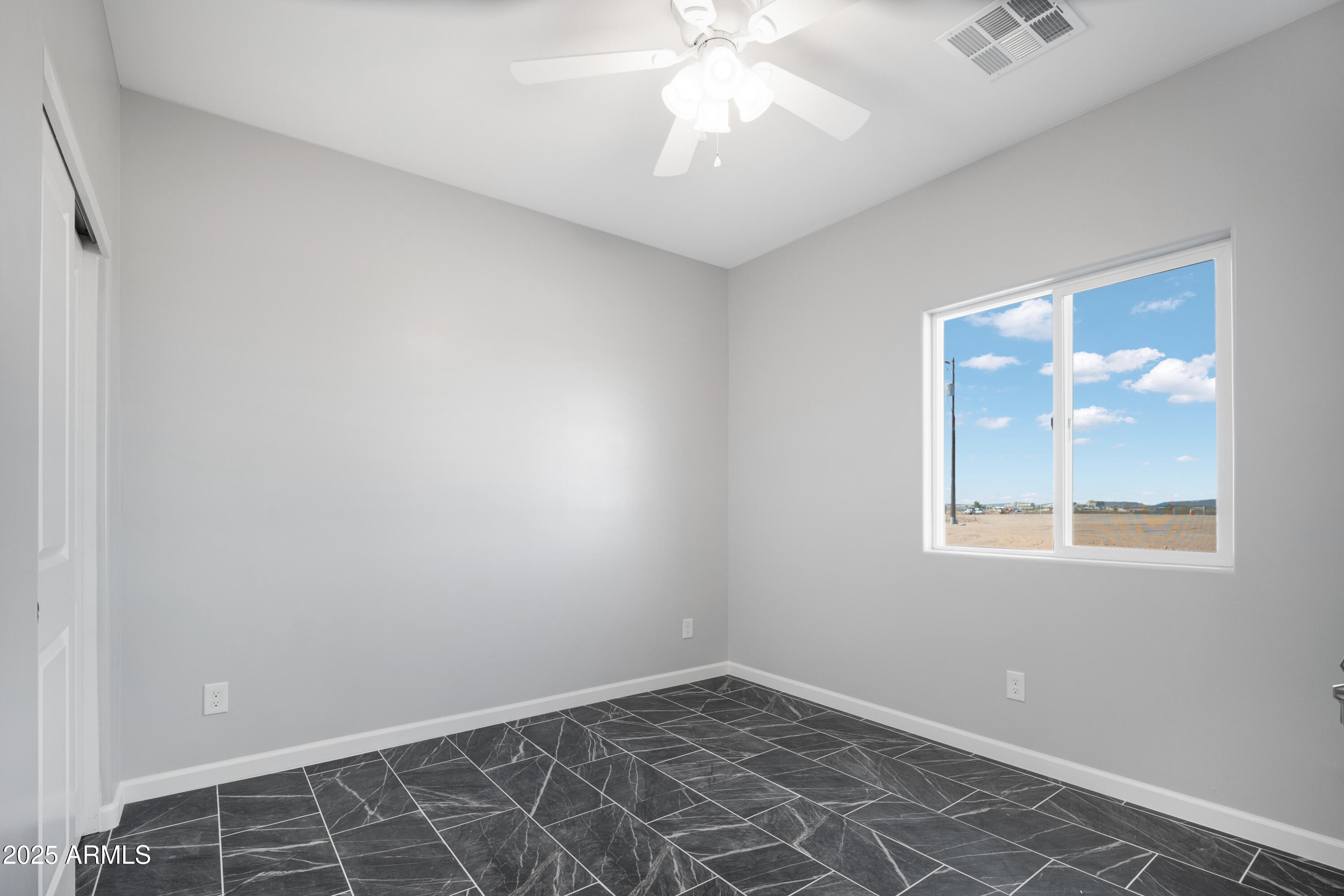 35532 West Chipman Road Tonopah, AZ 85354 - Photo 22 of 30 an empty room with a chandelier fan and windows
