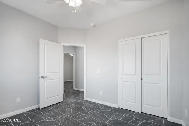 an empty room with closet and windows