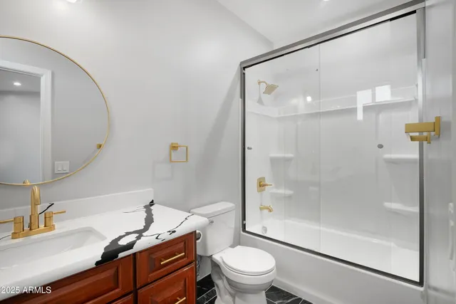 a bathroom with a granite countertop sink toilet and shower