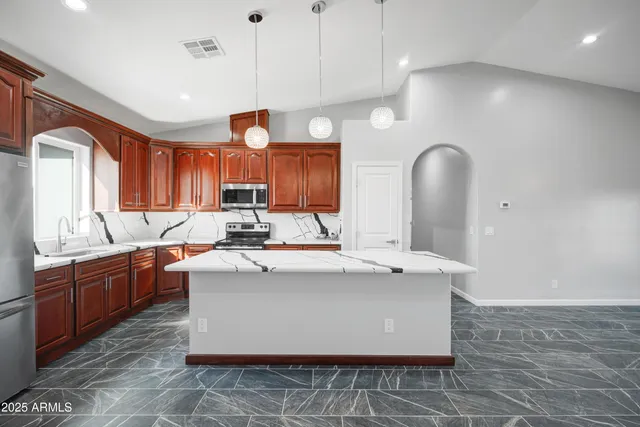 a large kitchen with kitchen island a sink stainless steel appliances and cabinets
