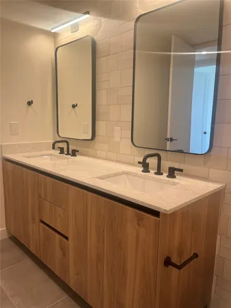 a bathroom with a double vanity sink and a mirror
