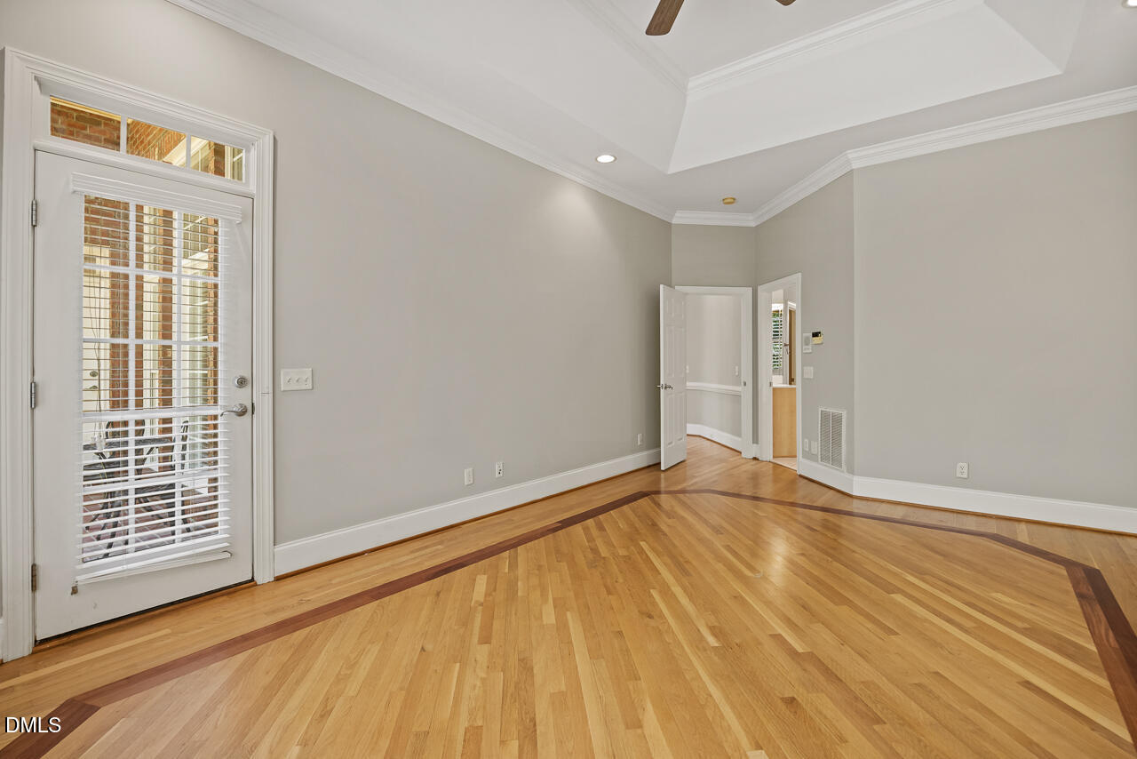 4004 Frontenac Court Apex, NC 27539 - Photo 27 of 61 a view of an empty room with wooden floor and a window