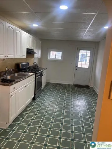 a kitchen with a sink a stove a microwave and cabinets