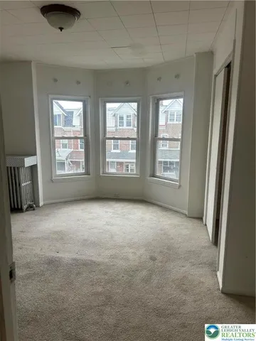 an empty room with windows and cabinet