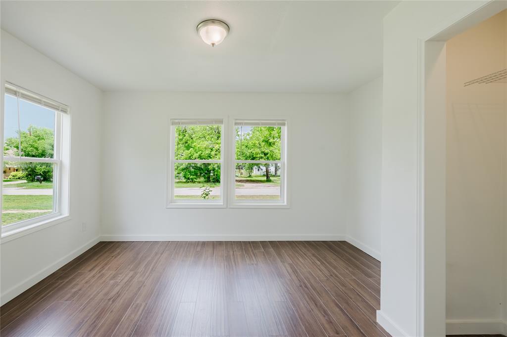 524 West Roberts Street Gorman, TX 76454 - Photo 24 of 35 an empty room with wooden floor and windows