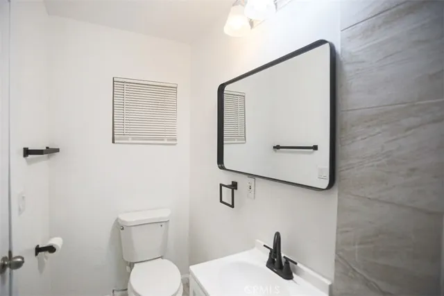 a bathroom with a toilet a sink and mirror