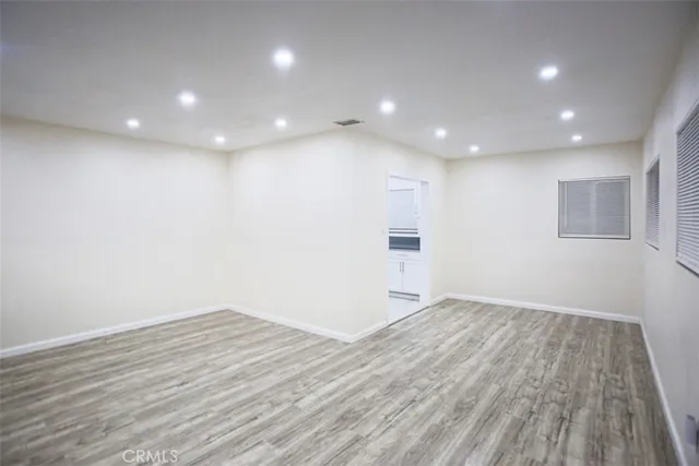 an empty room with wooden floor and entrance