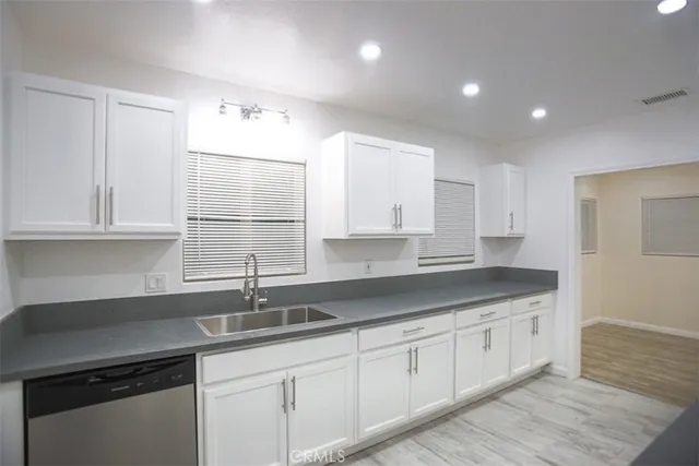 a kitchen with granite countertop white cabinets and sink