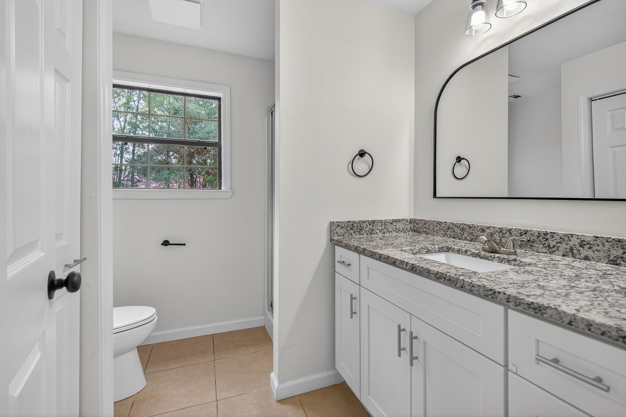 105 East Renoir Road DeFuniak Springs, FL 32433 - Photo 12 of 29 a bathroom with a granite countertop sink a toilet and a mirror