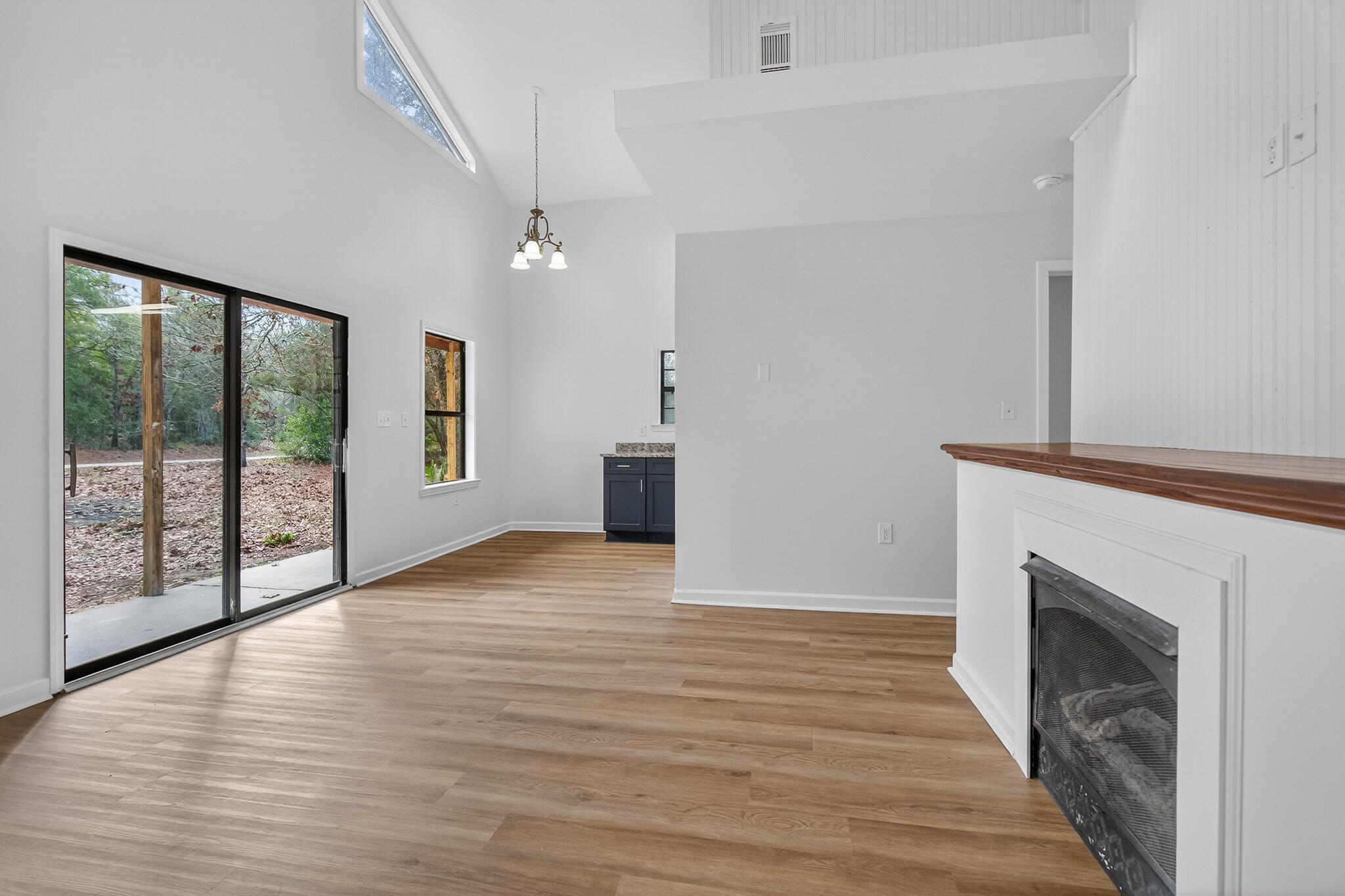 105 East Renoir Road DeFuniak Springs, FL 32433 - Photo 5 of 29 a view of empty room with wooden floor and fireplace