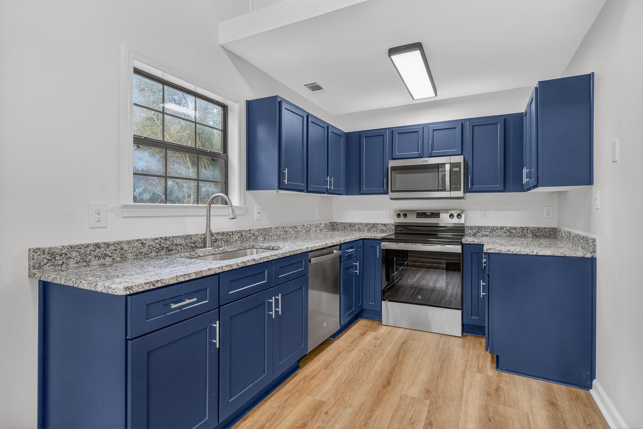 105 East Renoir Road DeFuniak Springs, FL 32433 - Photo 7 of 29 a kitchen with sink a microwave and wooden cabinets