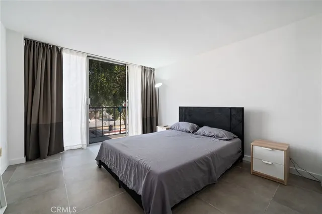 a large bed sitting in a bedroom next to a window