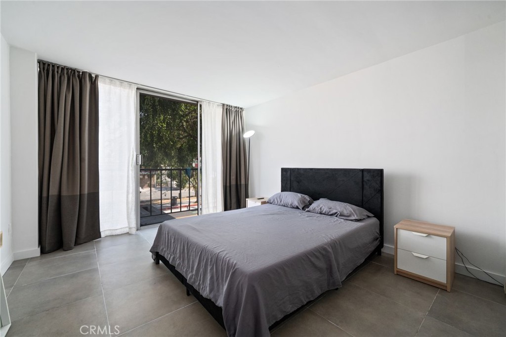 375 Atlantic Avenue, Unit 201 Long Beach, CA 90802 - Photo 16 of 21 a large bed sitting in a bedroom next to a window