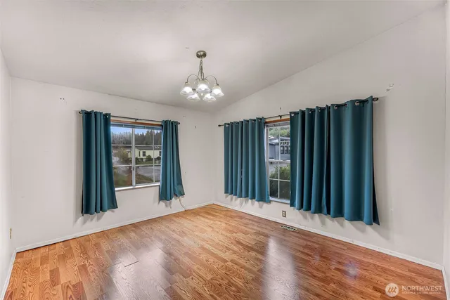 a view of an empty room with closet and a window