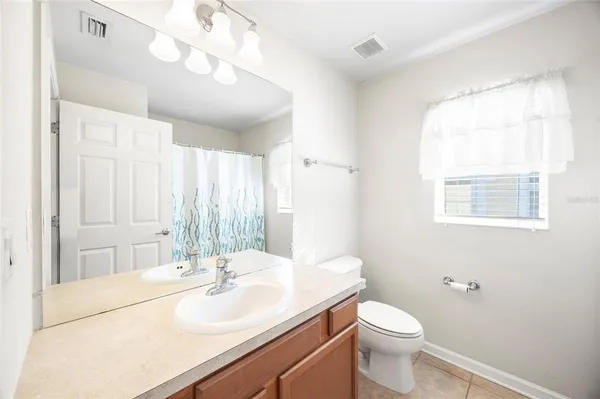a bathroom with a sink a toilet a mirror and vanity