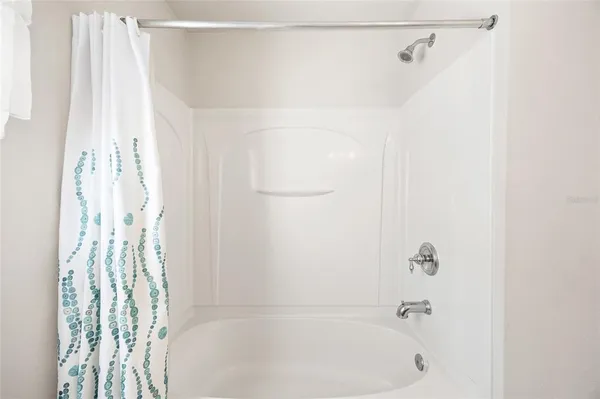 a bathroom with a shower curtain and a shower