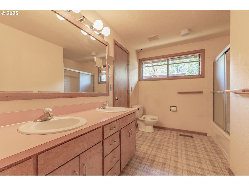 2116 Sally Way Eugene, OR 97401 - Photo 24 of 39 a bathroom with a sink a toilet and a mirror