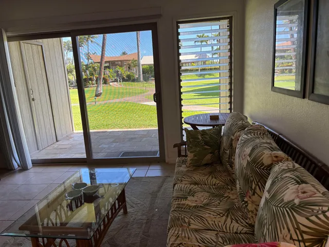 a living room with furniture and a floor to ceiling window