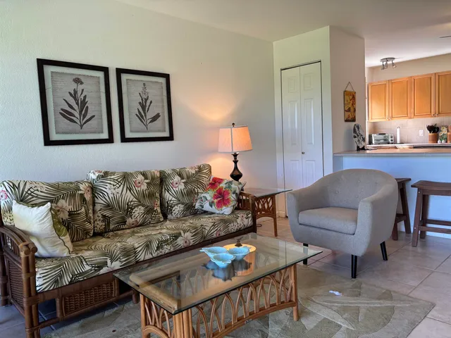 a living room with furniture and a dining table with wooden floor