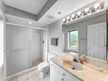 a bathroom with a sink a toilet and shower