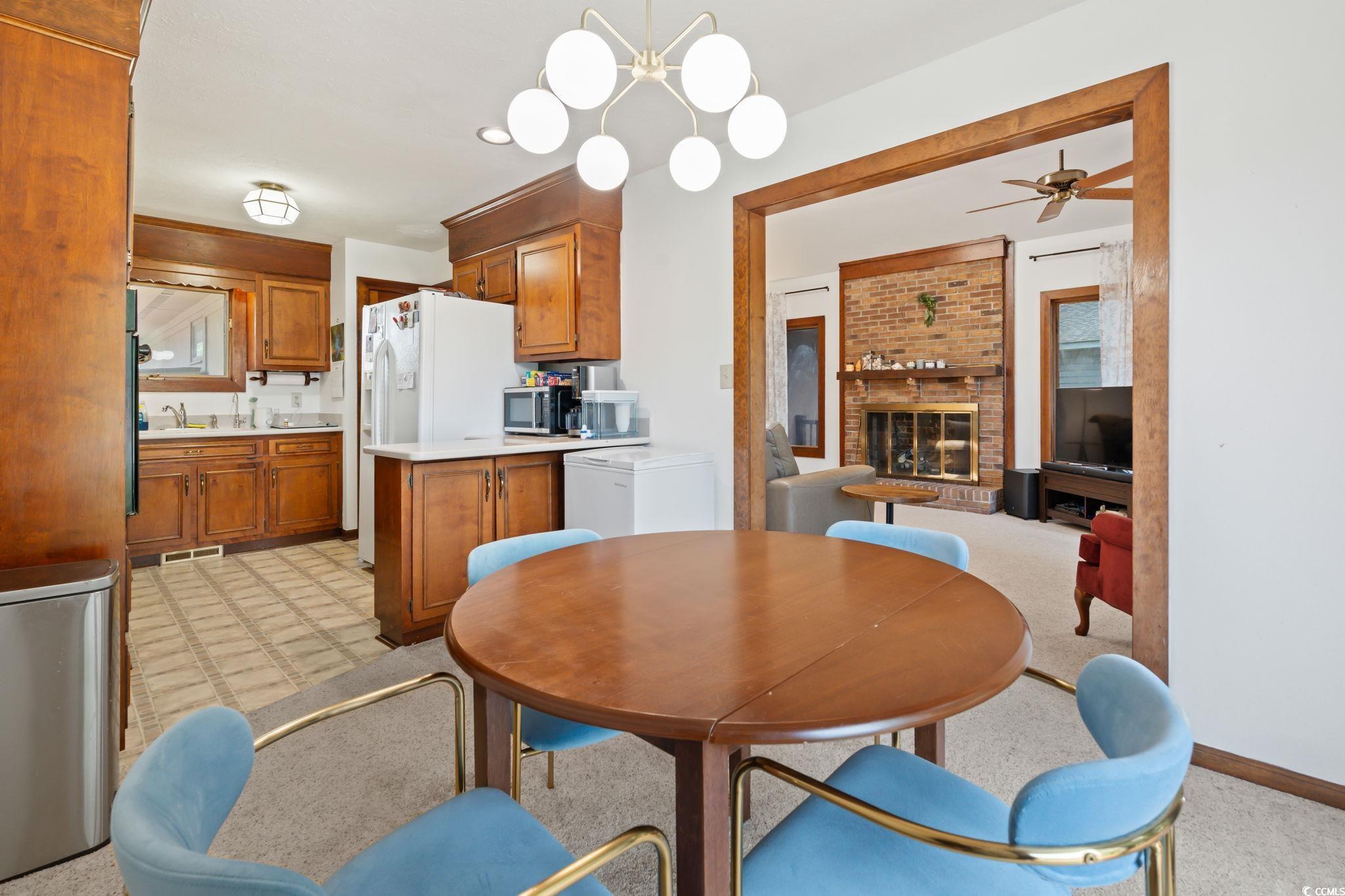 3533 Lighthouse Way Myrtle Beach, SC 29577 - Photo 13 of 40 Dining area with a ceiling fan, light colored carpet, and a fireplace