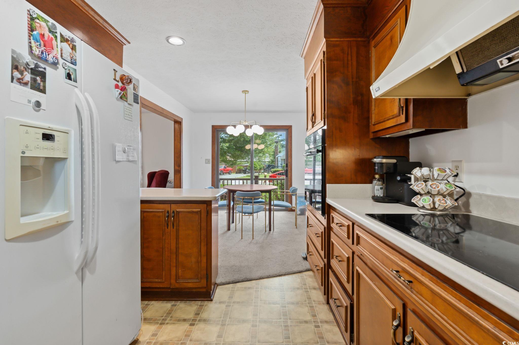 3533 Lighthouse Way Myrtle Beach, SC 29577 - Photo 18 of 40 Kitchen featuring black appliances, premium range hood, light countertops, brown cabinets, and recessed lighting