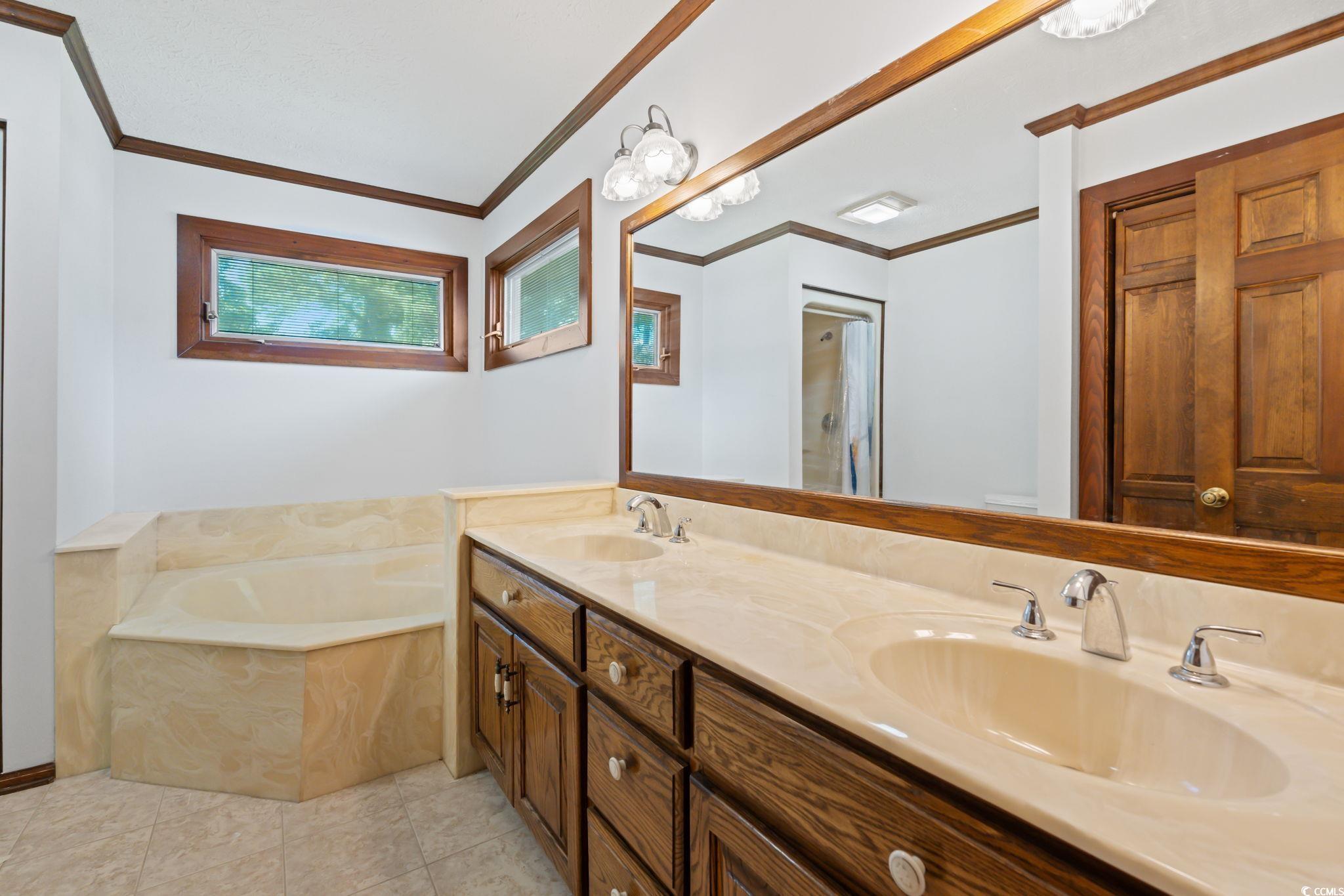 3533 Lighthouse Way Myrtle Beach, SC 29577 - Photo 23 of 40 Bathroom featuring ornamental molding, a bath, double vanity, and tile patterned floors