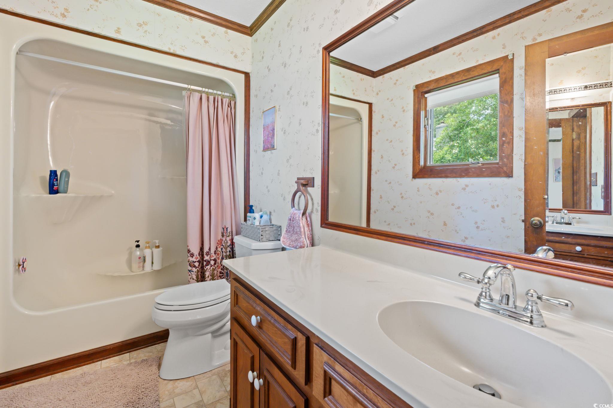3533 Lighthouse Way Myrtle Beach, SC 29577 - Photo 27 of 40 Bathroom featuring ornamental molding, wallpapered walls, vanity, and shower / bath combination with curtain