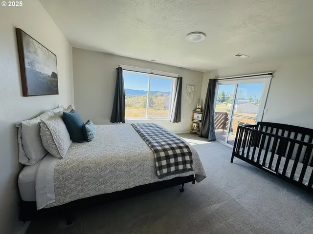 a bedroom with a bed and a flat tv screen on the dresser