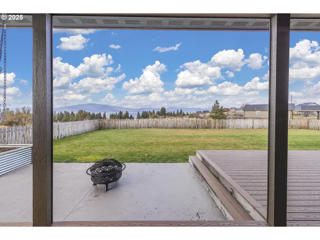 a view of a yard with wooden fence
