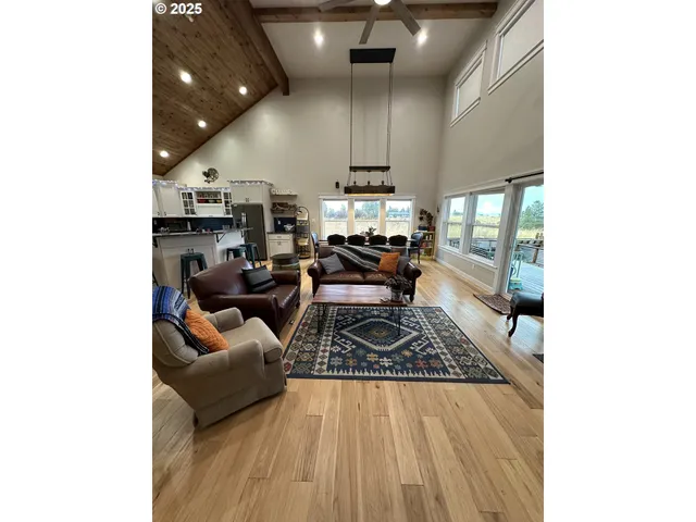a large kitchen with stainless steel appliances kitchen island granite countertop a sink and white cabinets