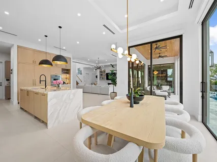 a kitchen with stainless steel appliances wooden floor dining table and chairs