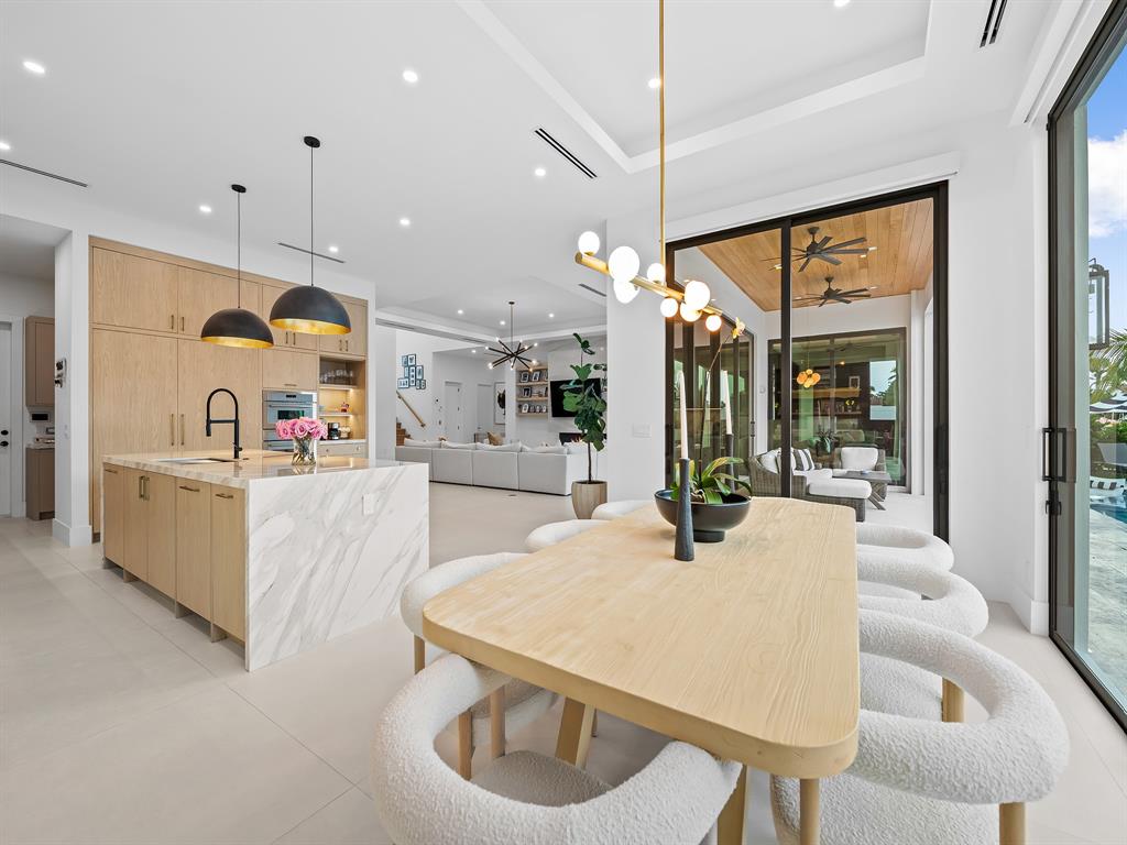 2420 Northeast 48th Street Lighthouse Point, FL 33064 - Photo 14 of 51 a kitchen with stainless steel appliances wooden floor dining table and chairs