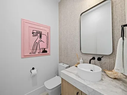 a bathroom with a granite countertop sink mirror vanity and toilet