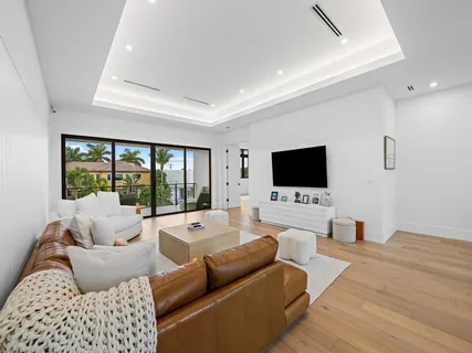 a living room with couches a flat screen tv and a large window