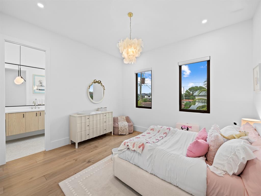 2420 Northeast 48th Street Lighthouse Point, FL 33064 - Photo 25 of 51 a bedroom with a bed and a chandelier