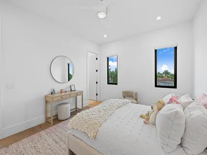 a bedroom with a bed a mirror and a window