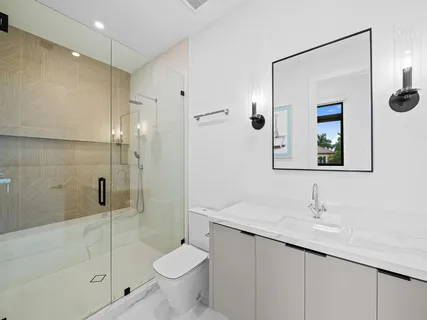 a bathroom with a granite countertop sink a toilet and shower